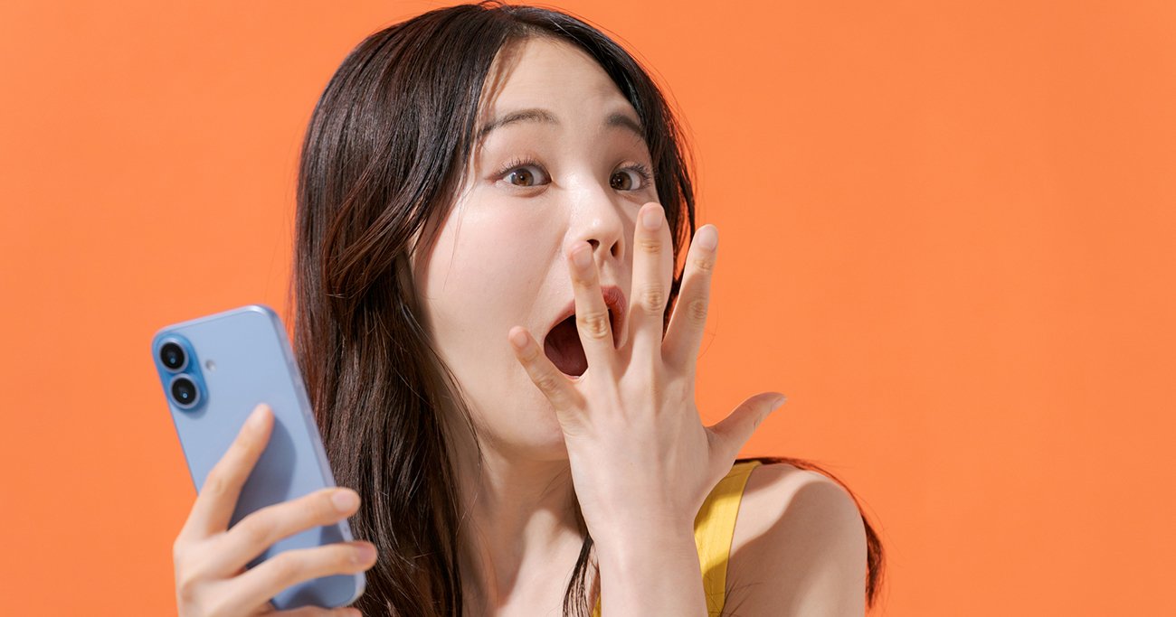 スマートフォンを持って驚く女性