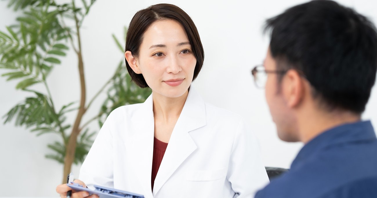 医師が患者の話を聞きながら診察する様子