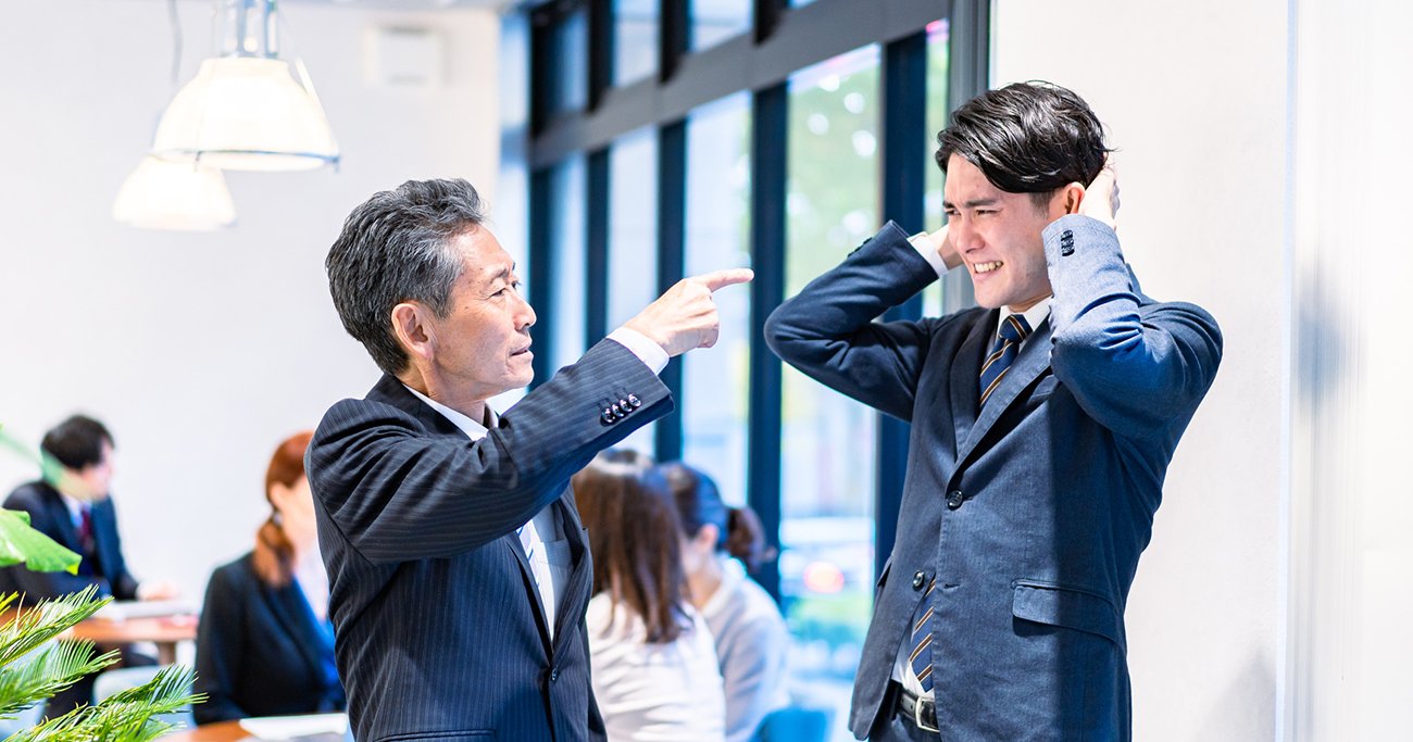 部下を指さして叱る上司