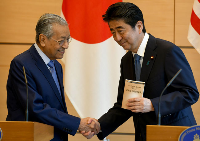 来日したマレーシアのマハティール首相と握手する安倍首相