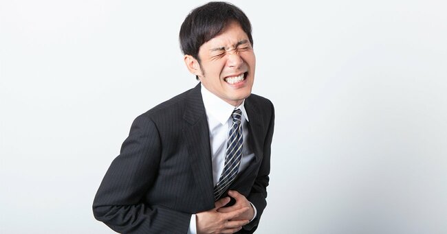 写真:腹痛に苦しむビジネスマン