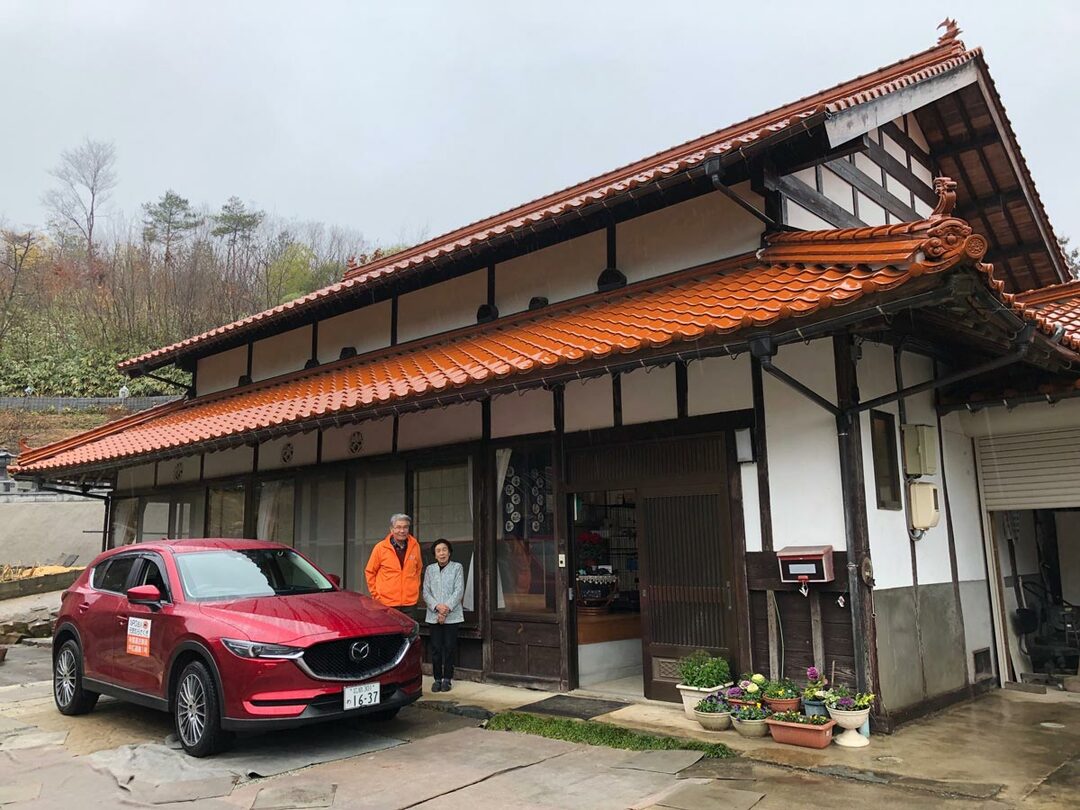 山本美智子さん宅の前にて。石州瓦屋根を使った大きな旧家