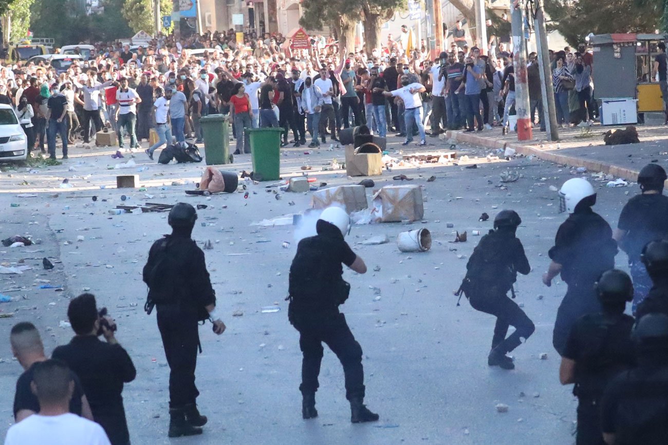 デモ隊（奥）に催涙弾を撃ち込むパレスチナ自治政府治安部隊