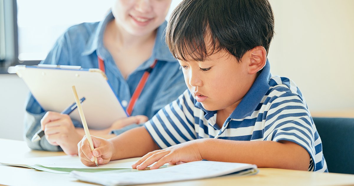 ノートに書き取りをする小学生の男の子