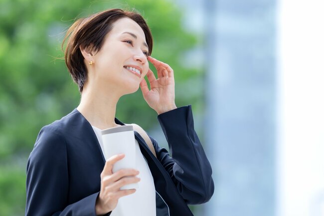 タンブラーを片手に歩く女性