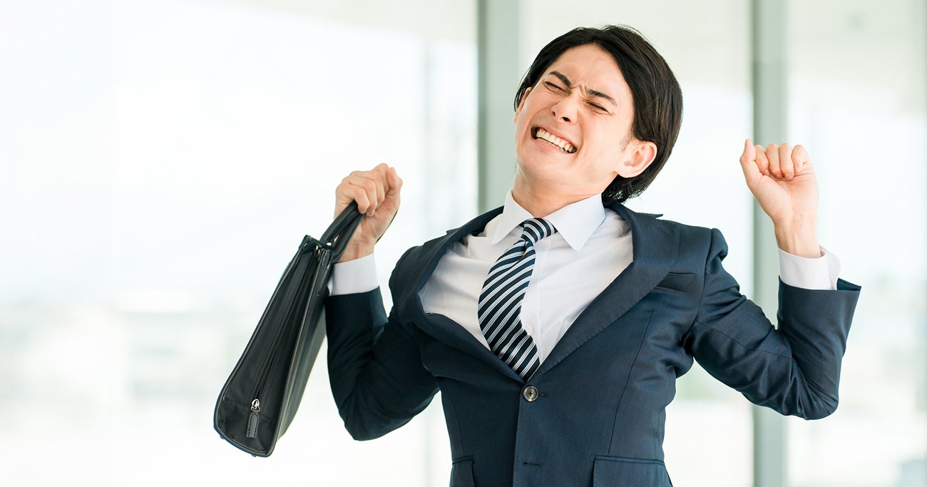 大きく伸びをするスーツ姿の男性