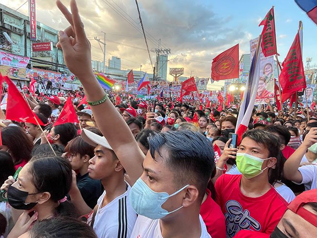 熱狂するフィリピンの若者たち。シンボルマークのVサインをする人、キャンペーンカラーの赤が目立つ　Photo by T.M