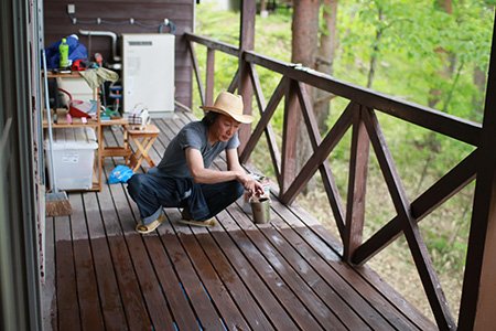 テラスにオイルステインを塗る著者