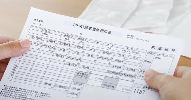 医療費の請求書を見つめる女性