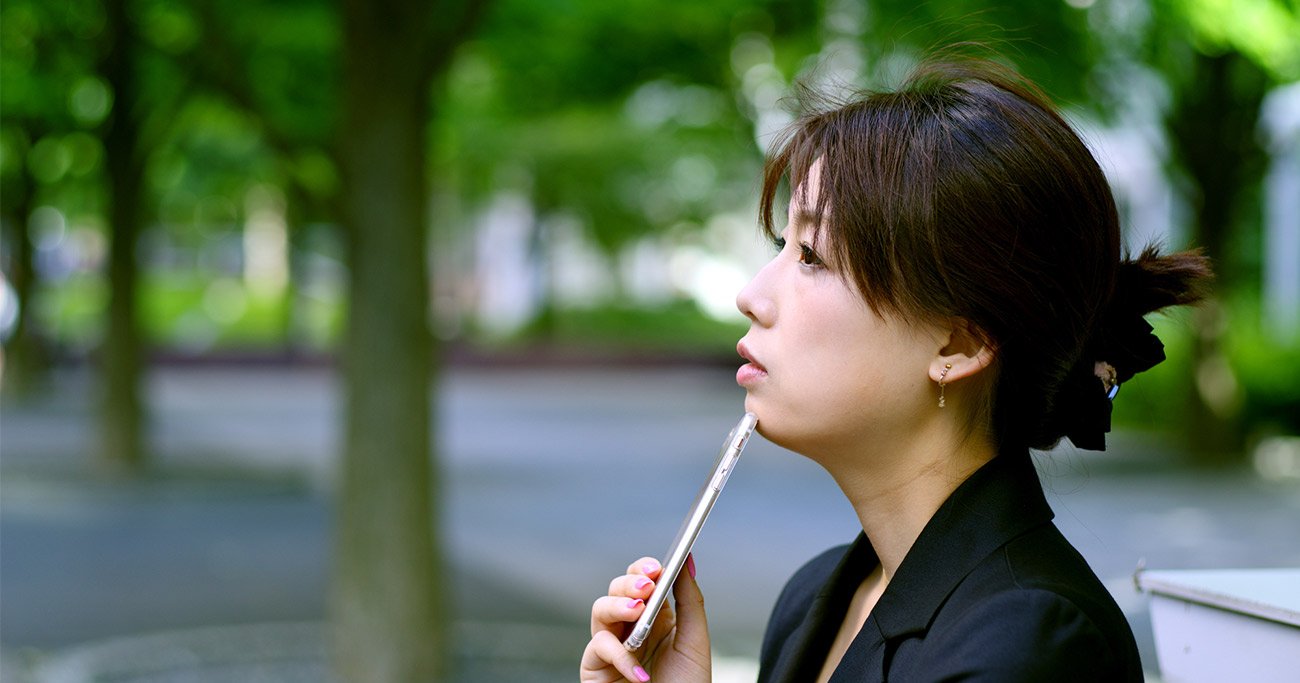 スーツ姿で悩む女性のイメージ写真