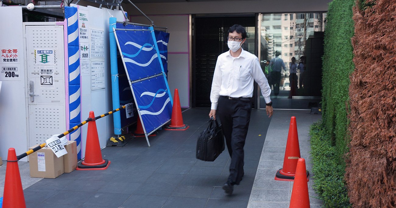 家宅捜索した元副社長宅から出る東京地検の係官=18日午後、東京都渋谷区