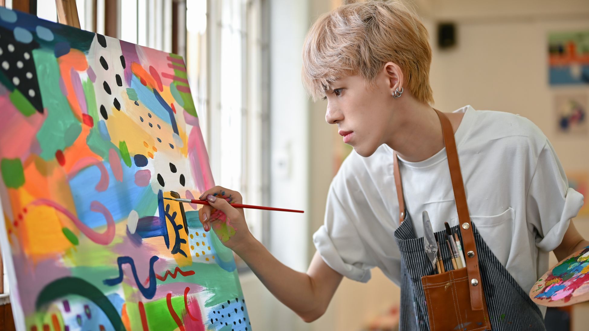 絵画を描く若い金髪の男性