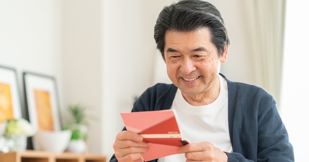 貯金通帳を見るミドルの男性