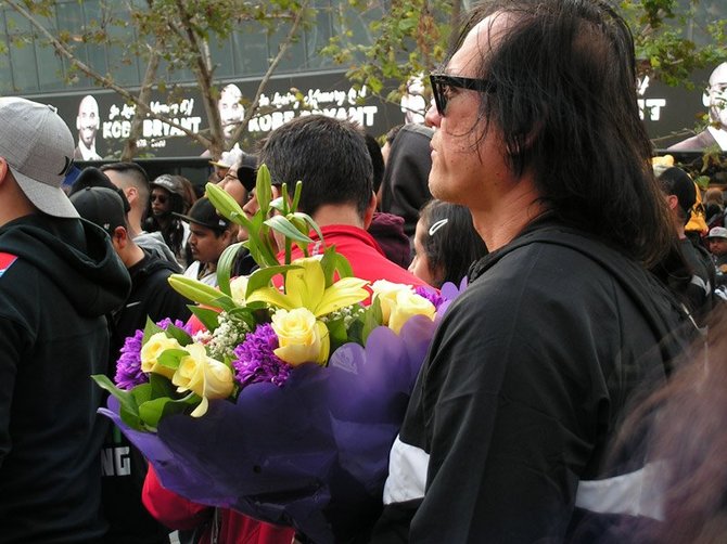 黄色と紫の花束を手にする人