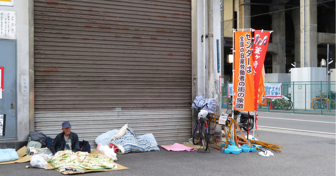 あいりん労働福祉センターの外で寝泊まりするホームレス男性