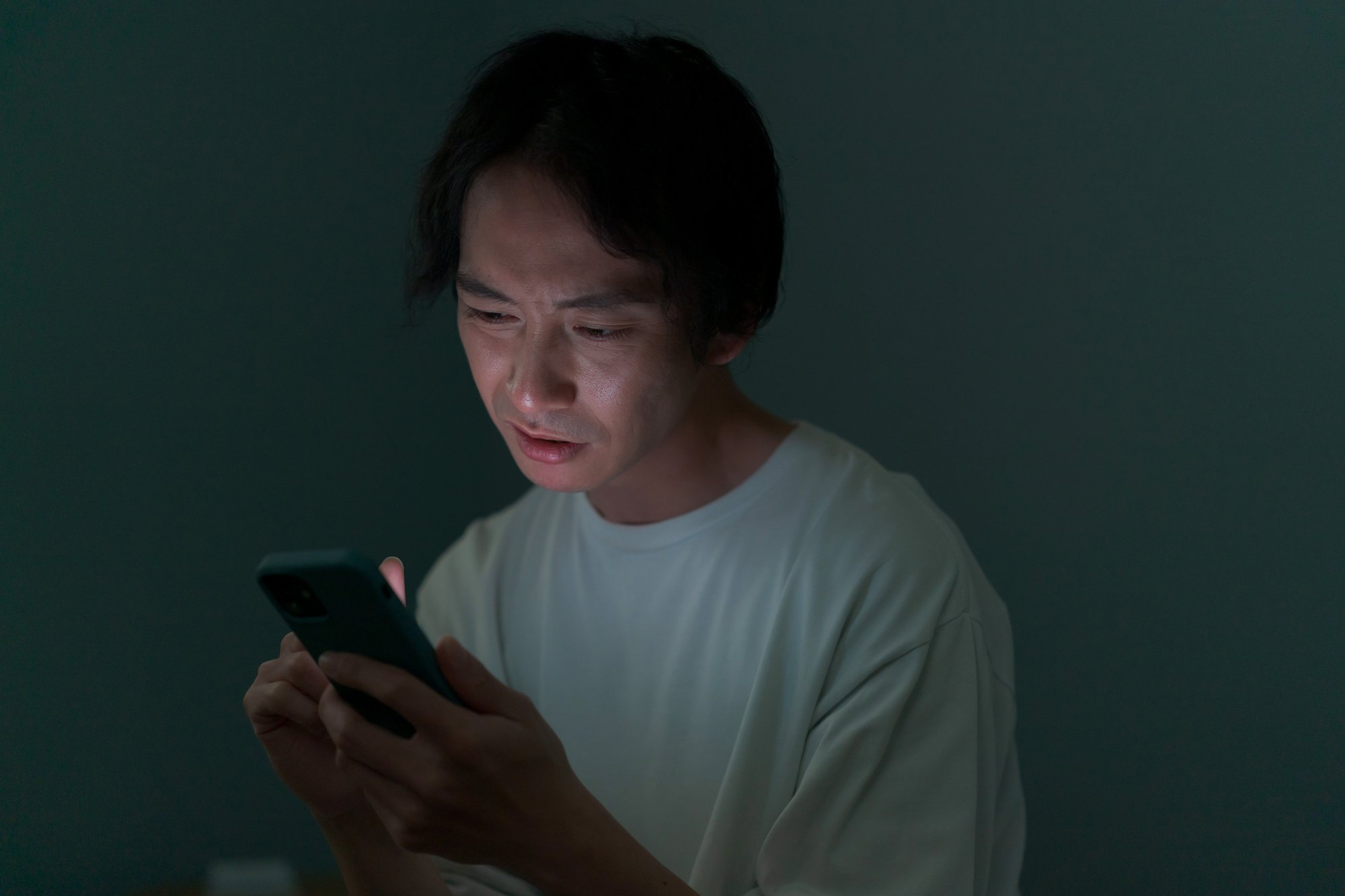 スマホを見て絶望した表情を浮かべる男性
