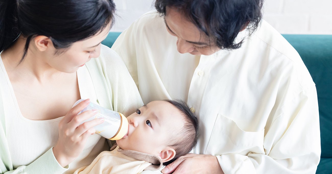 赤ちゃんにミルクを与える両親