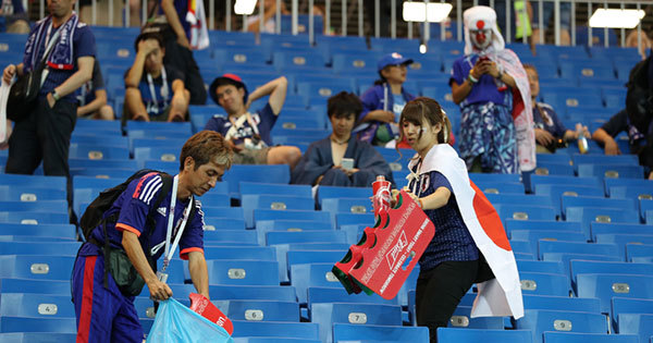 決勝トーナメント1回戦後、ゴミ拾いをする日本人サポーター