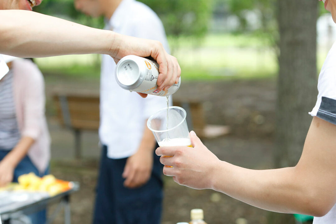 バーベキューでアルコールを飲む男性