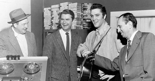テネシー州メンフィスにあるサン・レコードの録音スタジオにてのレコーディング時に撮影した1枚。左から2番目がサム・フィリップス、その右隣がエルヴィス・プレスリー（1956年12月撮影）