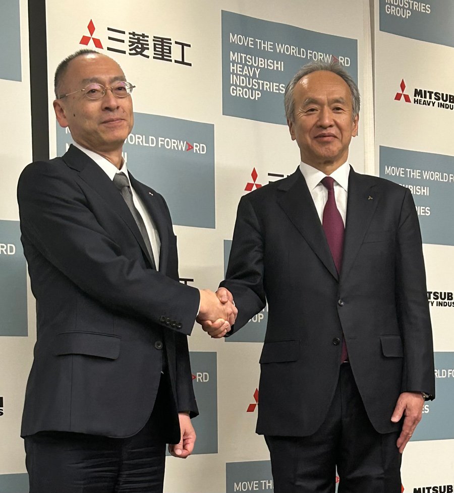 握手する三菱重工業の伊藤栄作氏（左）と泉沢清次氏