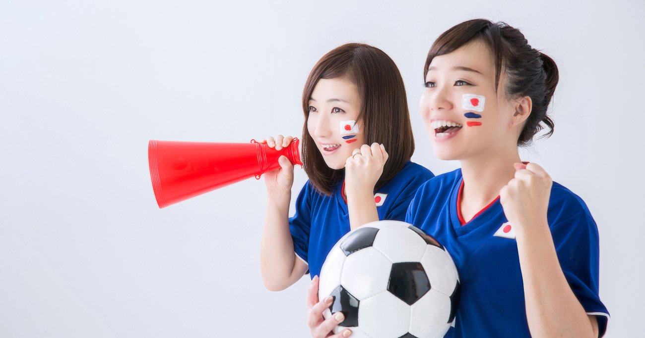 ユニフォーム姿でサッカーを応援する女性2人