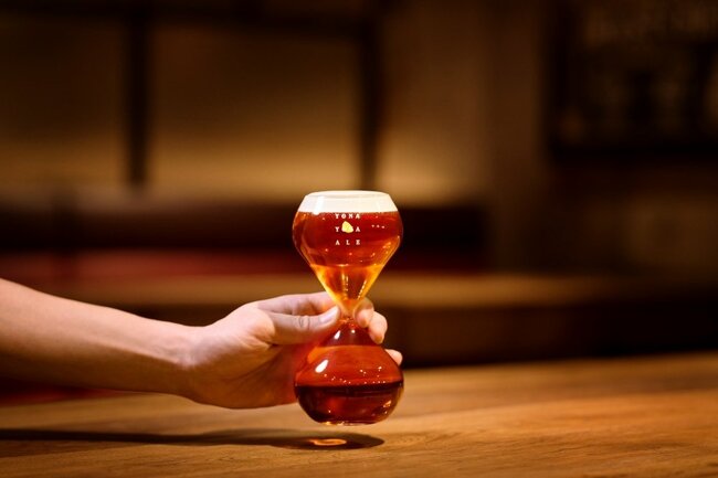 ビールの「飲みづらさ」を追求した「ゆっくりビアグラス」は、砂時計のような形をしている