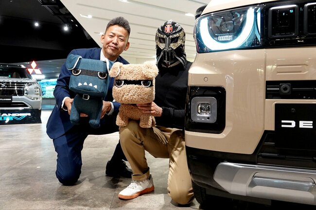 三菱自動車の藤井さん（左）とフェルさんに、デリ丸。のぬいぐるみを持っていただいてパチリ