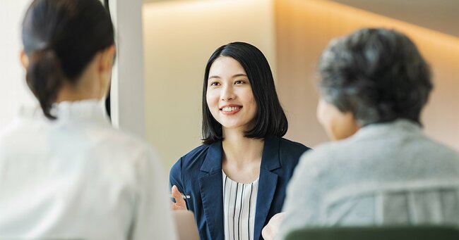 親子に説明をするキャリアウーマン