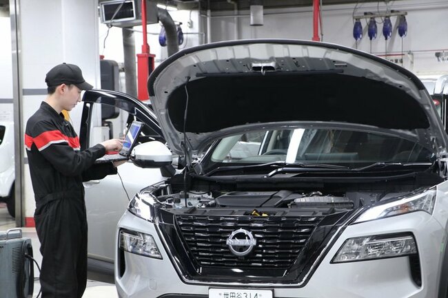 専用の端末でクルマに異常がないか検査する日産東京販売HDの整備士