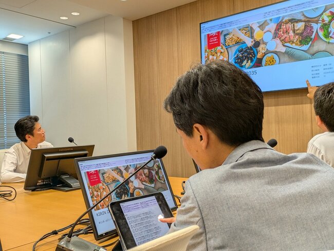 投影画面の上に、AI役員による論点が提示されている
