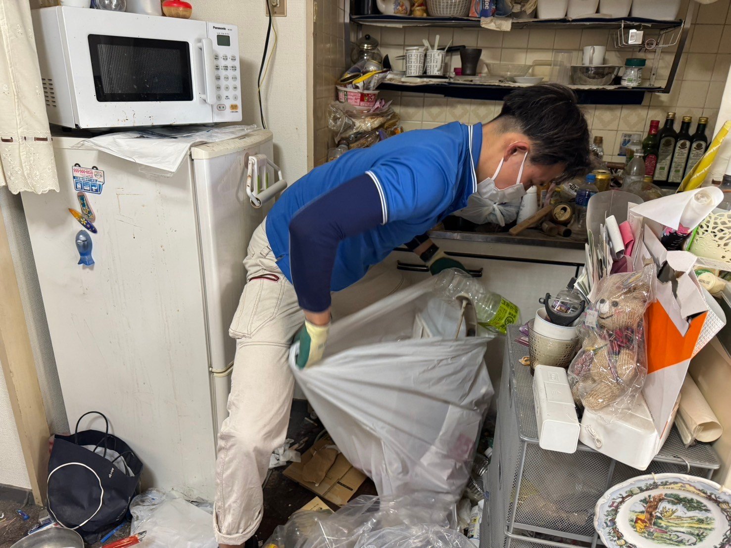 実際の作業の様子。軍手をはめていれば、先の尖ったモノや壊れたモノが出てきても安全に対処できる。(イーブイ片付けチャンネル提供)