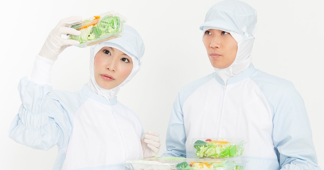 食品を持つ防護服姿の男女