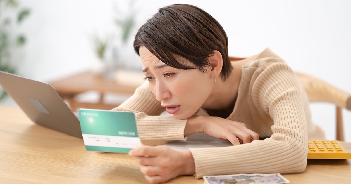 通帳を見て悩む女性
