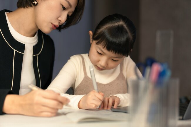 家庭教師と勉強する小学生の女の子