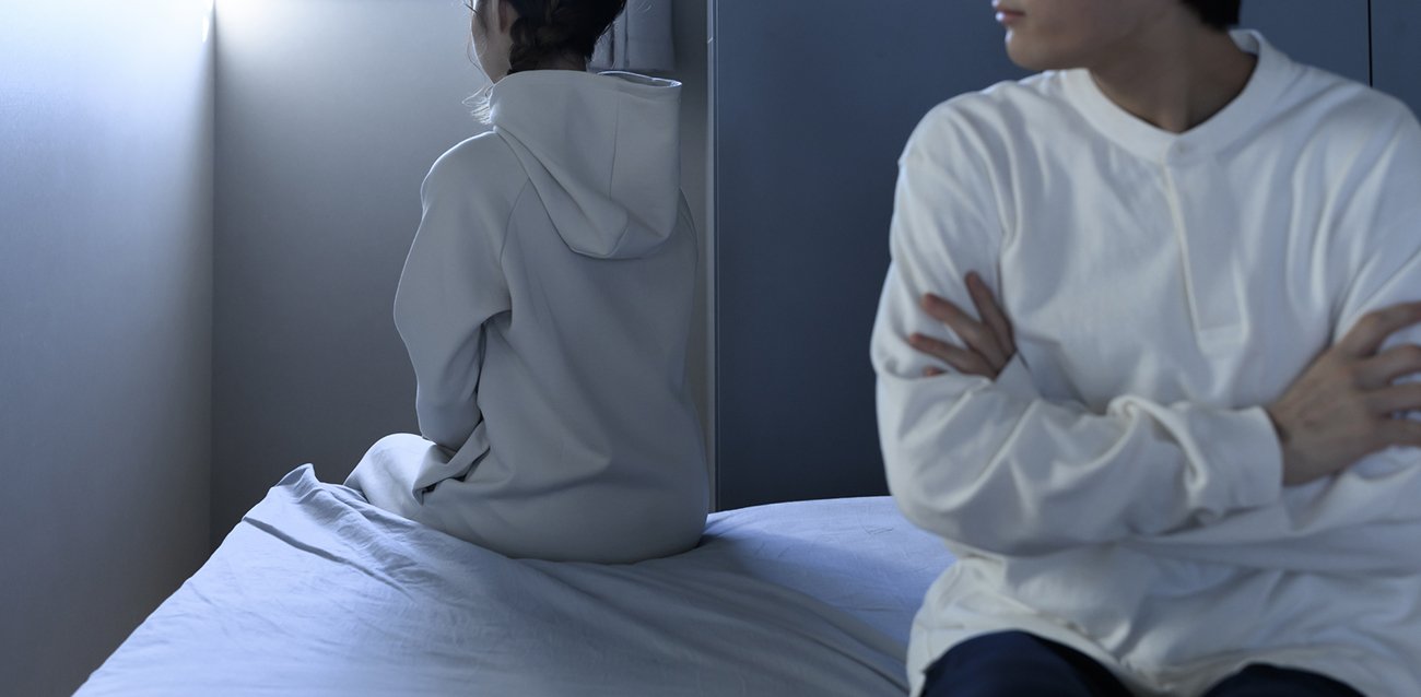 ベッドの上で背を向け合う男女