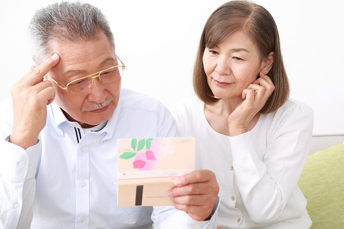 通帳を眺める夫婦