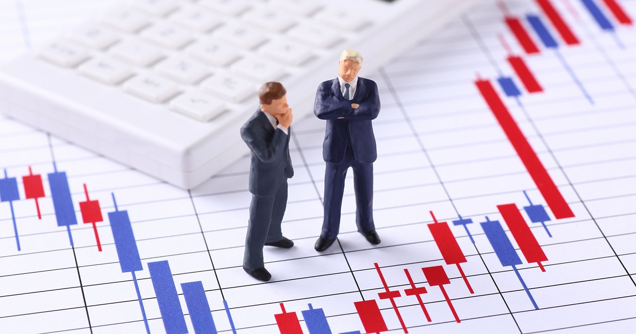 株価チャートとビジネスパーソンのミニチュア