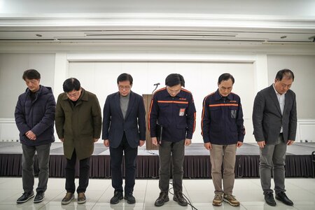 韓国ソウルで開かれた記者会見で、謝罪の言葉を述べる済州航空のキム・イベCEO（右）と同社関係者