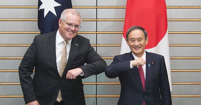 首脳会談でひじを合わせる菅義偉首相（右）とオーストラリアのスコット・モリソン首相／11月17日、首相官邸