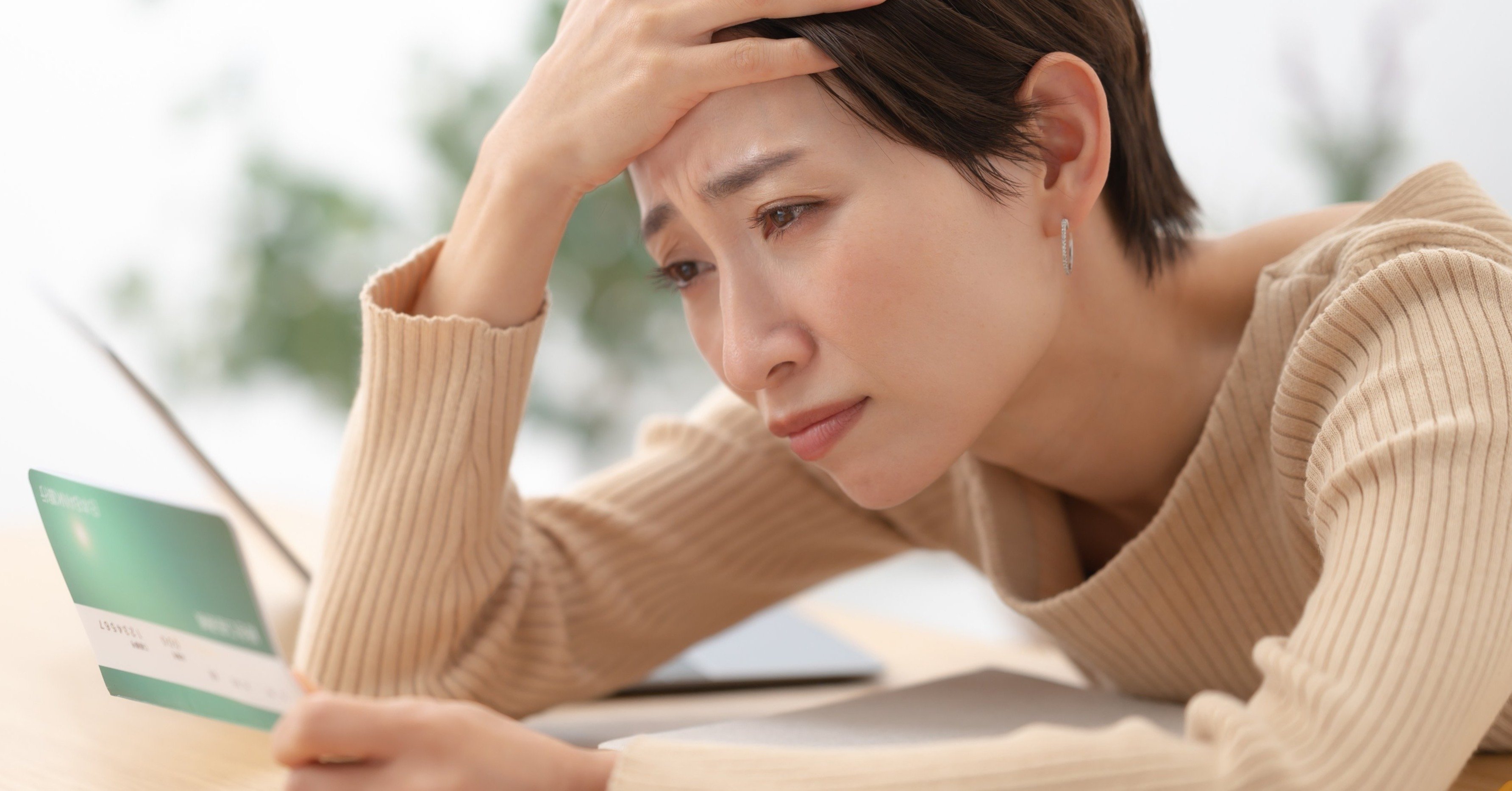 通帳を見て絶望する女性