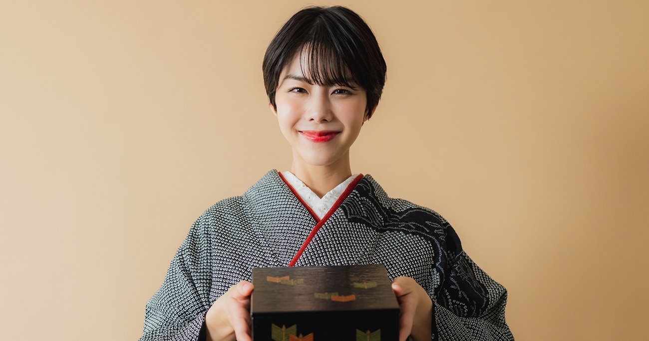 着物姿で重箱を手に持つ女性