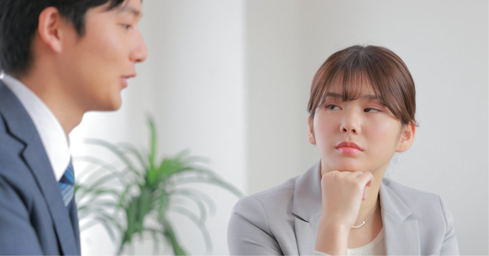 同僚の男性を睨みつける女性の画像