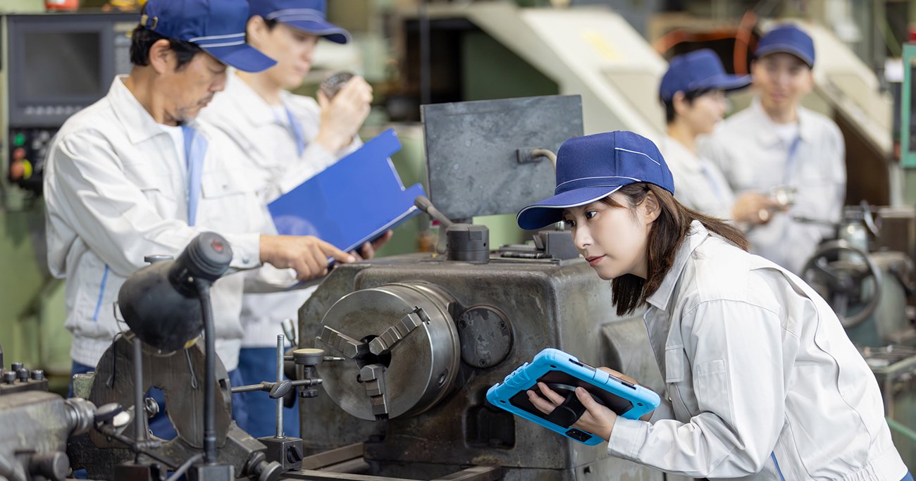 工場で機械を点検する作業員たち