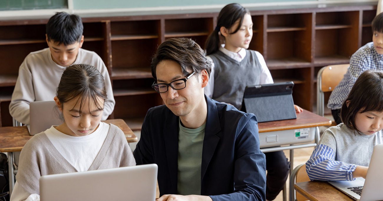 教師が児童の学習をサポートする学校の授業風景
