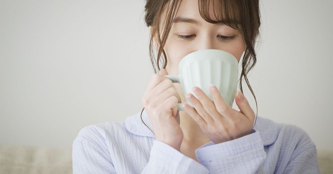 パジャマ姿でマグカップを持つ女性