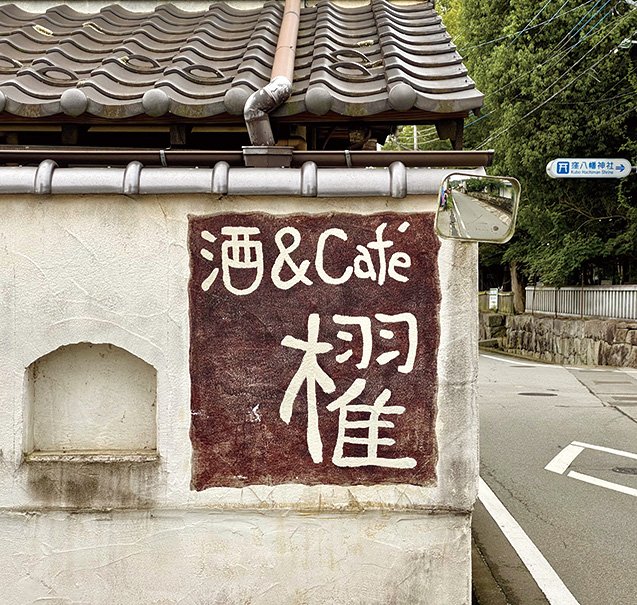 カフェの看板の奥は鎮守の森
