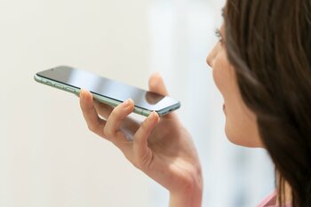 スマホに音声入力をする女性