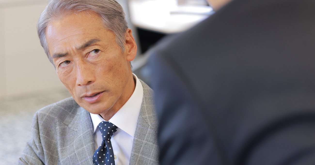 部下を厳しい表情で見つめる中高年の上司