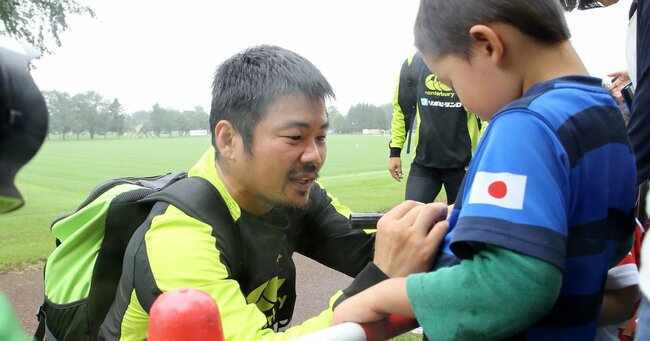 2019年ラグビーW杯前の網走合宿で子どもにサインをする田中史朗